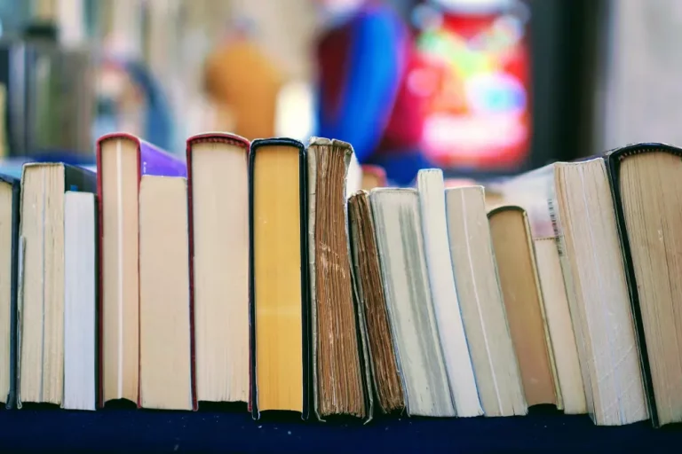 une rangée de livres sur la tranche posés sur une table