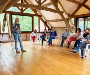 Groupe de personne assis autour d'un homme debout face à un paperboard